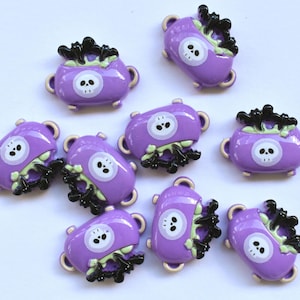 May include: Eight purple cauldron shaped buttons with black bats and a white skull design.