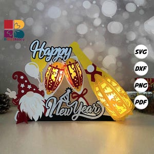 Può includere: Decorazione di Capodanno con uno gnomo, una bottiglia di champagne e bicchieri. Le parole "Happy New Year" sono in argento. Il design è rosso, bianco e giallo. I bicchieri e la bottiglia brillano.