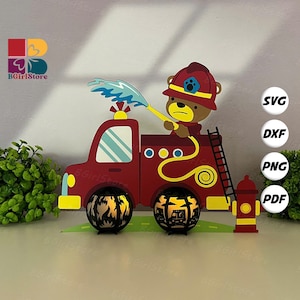 Może przedstawiać: Czerwono-żółty wóz strażacki z misiem strażakiem spryskującym wodą. Wóz ma drabinę, hydrant i dwie dekoracyjne latarnie. Obraz zawiera tekst "SVG, DXF, PNG, PDF" oraz logo "BGirlStore".