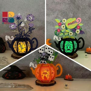 May include: Three Halloween-themed decorative teapots with cut-out designs. One is blue with purple flowers and a skeleton, another is green with a monster and the last is orange with a cat. Each teapot sits on a wooden base and glows.