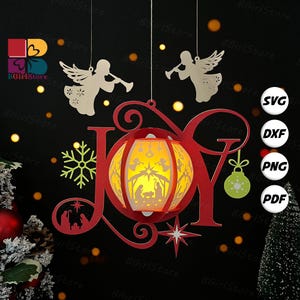 May include: A red Christmas decoration spelling "JOY" with a lantern featuring a nativity scene. Includes a snowflake, star, and ornament. Two angel silhouettes and file type icons are also present. The background is black with bokeh lights.