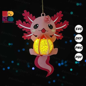 May include: A pink axolotl-shaped paper lantern with a glowing yellow light inside. The lantern has a flower on its head and is hanging from a string. The design includes a decorative pattern and is suitable for crafting projects.