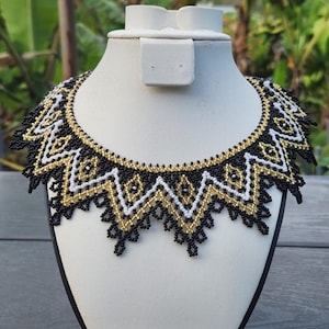 May include: A white-painted wooden 'Welcome' sign with a distressed finish. The sign features a floral design in pink and green. The text is in a whimsical font. Suitable for indoor or outdoor use. The sign is handmade.