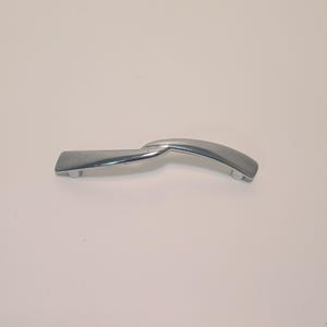 May include: A chrome-finished cabinet handle with a curved, ergonomic design. The handle features a rectangular base on one end and a rounded end on the other, connected by a curved section. The handle is designed for easy gripping and pulling.