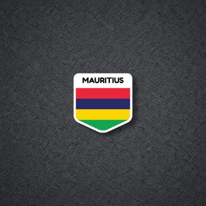 May include: A white, shield-shaped sticker with the word "MAURITIUS" at the top. The sticker features the flag of Mauritius: red, blue, yellow, and green horizontal stripes. The sticker is on a dark gray textured background.