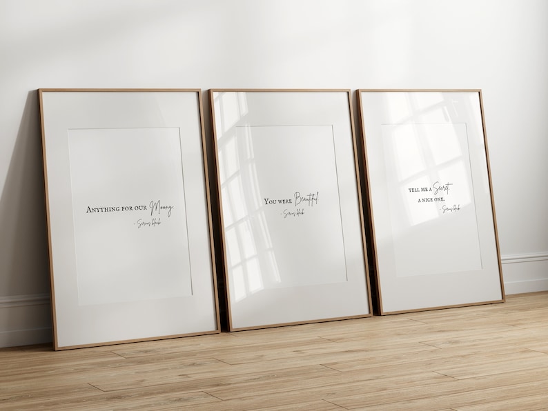 May include: Three framed prints with white backgrounds and black text. The prints feature quotes from the song "You Were Beautiful" by James Blunt. The quotes are "Anything for our money", "You were beautiful", and "Tell me a secret, a nice one."
