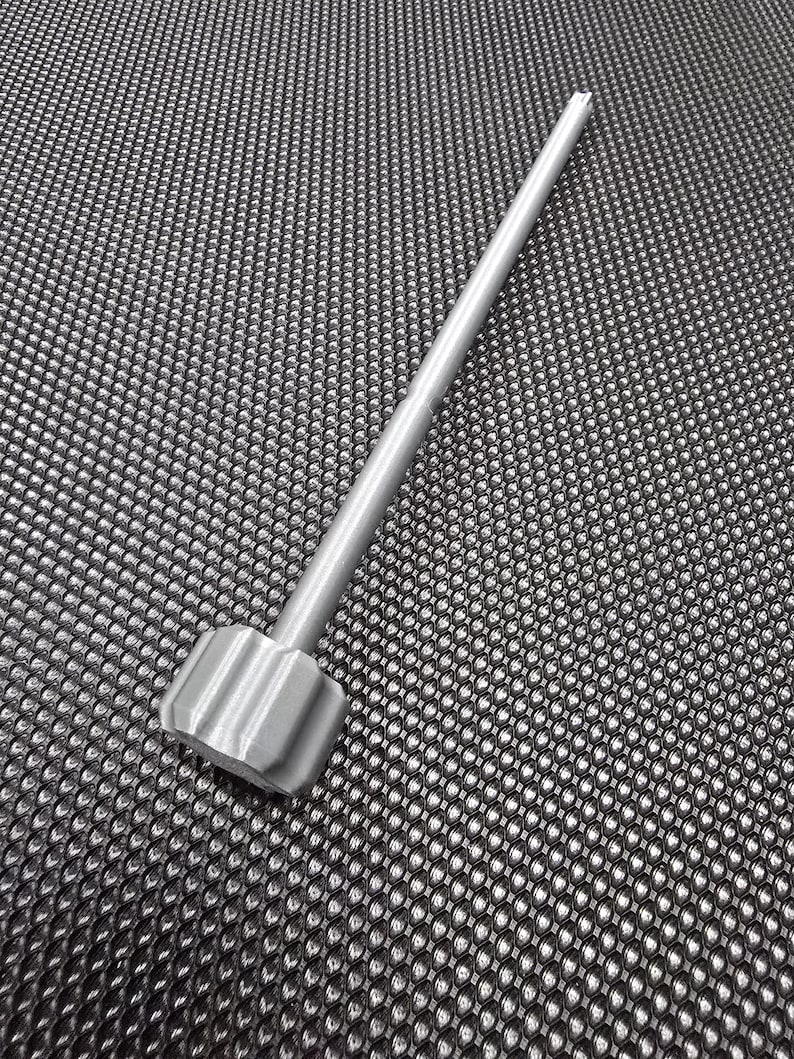 May include: A silver metal tool with a hexagonal head and a long, straight shaft.