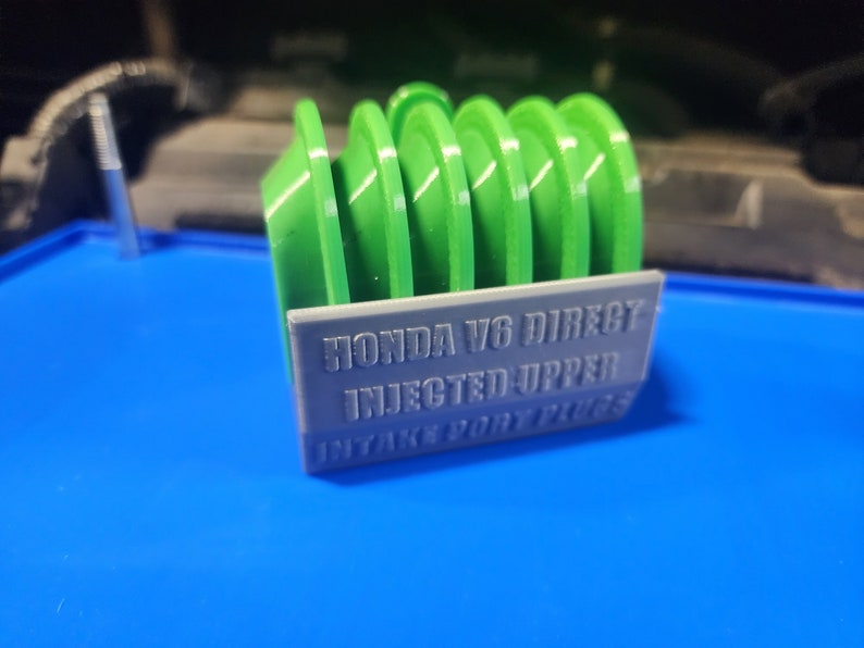 K&ouml;nnte beinhalten: Ein 3D-gedruckter Einlasskr&uuml;mmer-Spacer aus gr&uuml;nem und grauem Kunststoff f&uuml;r einen Honda V6 mit direkter Einspritzung im oberen Einlasskr&uuml;mmer.