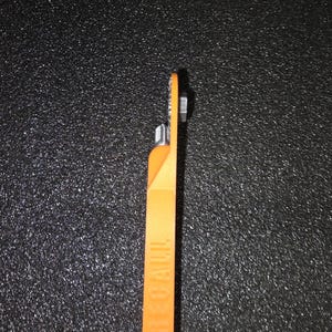 May include: An orange plastic tool with a metal tip. The tool has the word "SEAL-A-MEAL" printed on the side.