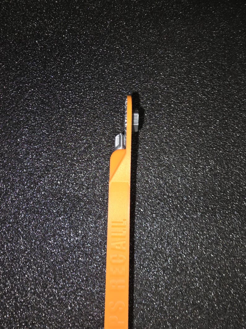 May include: An orange plastic tool with a metal tip. The tool has the word "SEAL-A-MEAL" printed on the side.
