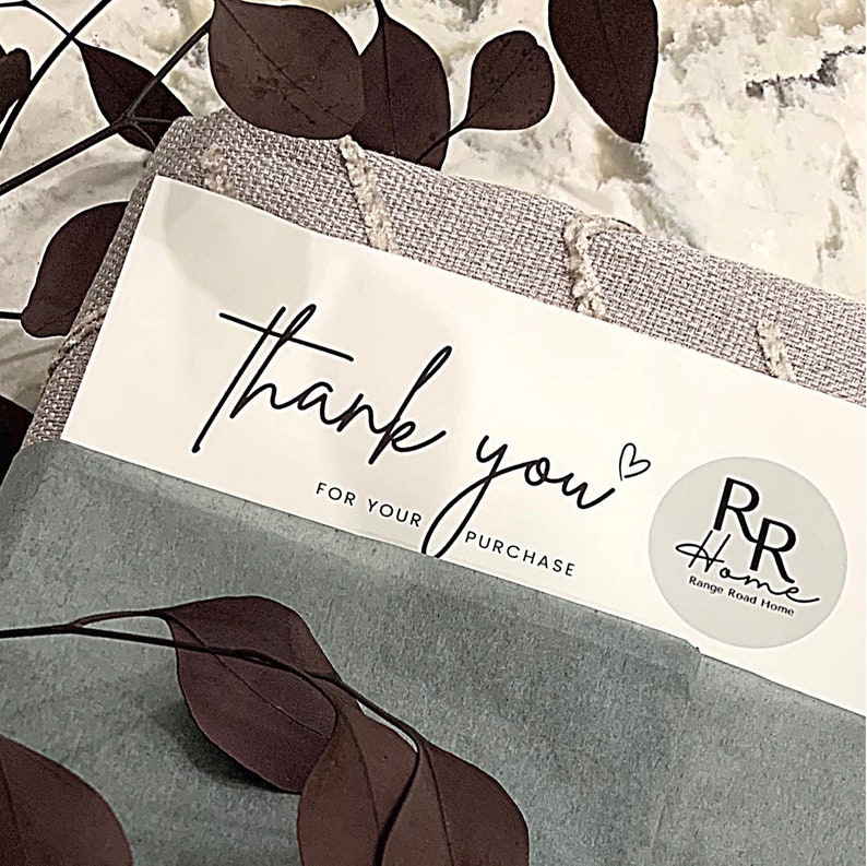 May include: A white thank you card with black script that says "thank you" with a heart symbol and "for your purchase". A round sticker with the text "RR Home Range Road Home" is in the bottom right corner.