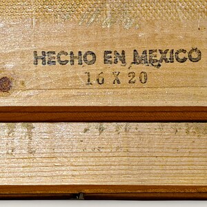 May include: Close-up of two wooden planks with the text "HECHO EN MEXICO" and "16 X 20" printed in black. The wood has a light brown color with visible grain and knots. The planks are arranged horizontally.