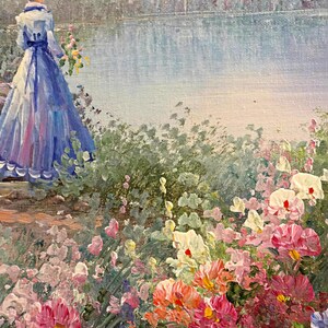 May include: An impressionistic painting depicts a woman in a blue dress and hat, standing near a lake. The foreground features a vibrant array of colorful flowers in shades of pink, red, orange, and white. The artwork evokes a serene, natural scene.