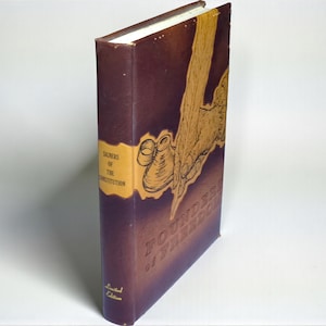 May include: A hardcover book with a dark burgundy cover and gold lettering. The title "Founders of Freedom" is embossed on the cover, along with an illustration of a quill and parchment. The spine features the title "Signers of the Constitution".