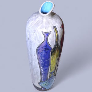 May include: A tall, white ceramic vase with a textured surface and a slanted, turquoise-colored opening. The vase is decorated with colorful, stylized bottle shapes in blue, yellow, and red.