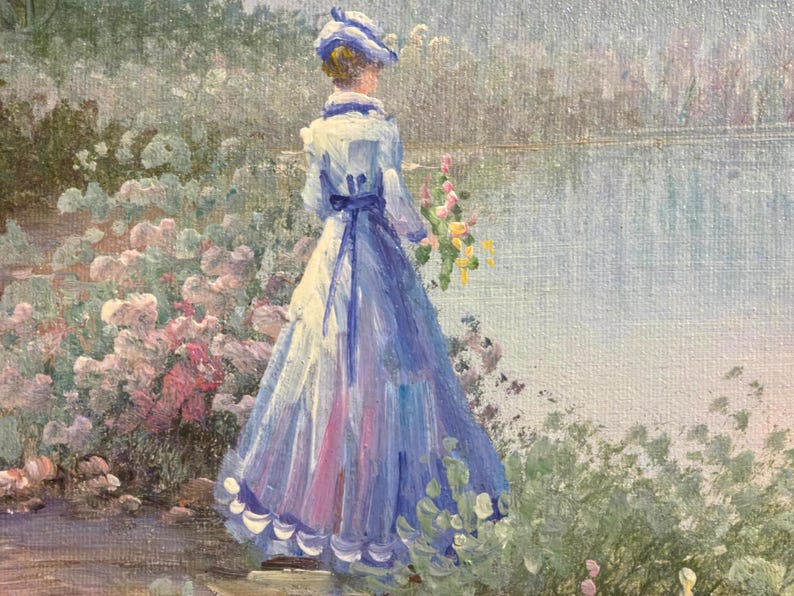 May include: Oil painting of a woman in a long blue dress and hat, standing near a body of water. She holds a bouquet of yellow flowers. The painting has a soft, impressionistic style with pink and green foliage.