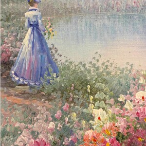 May include: Oil painting of a woman in a blue dress and hat standing near a lake. The painting features a garden of pink, purple, and white flowers in the foreground. The woman is holding a bouquet of yellow flowers.