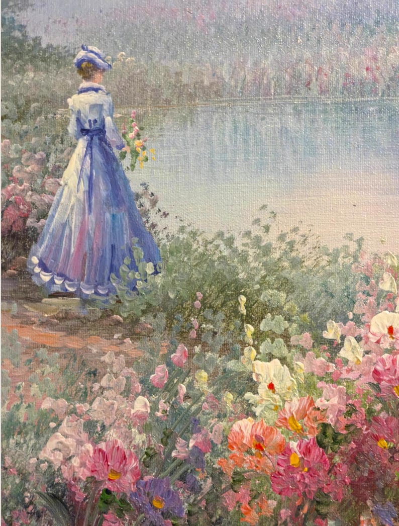 May include: Oil painting of a woman in a blue dress and hat standing near a lake. The painting features a garden of pink, purple, and white flowers in the foreground. The woman is holding a bouquet of yellow flowers.