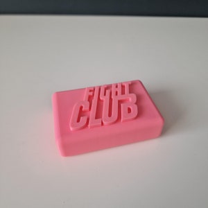 May include: A pink soap bar with the words "FIGHT CLUB" embossed on the top.