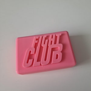 May include: A pink rectangular soap bar with the words "FIGHT CLUB" embossed on the top.