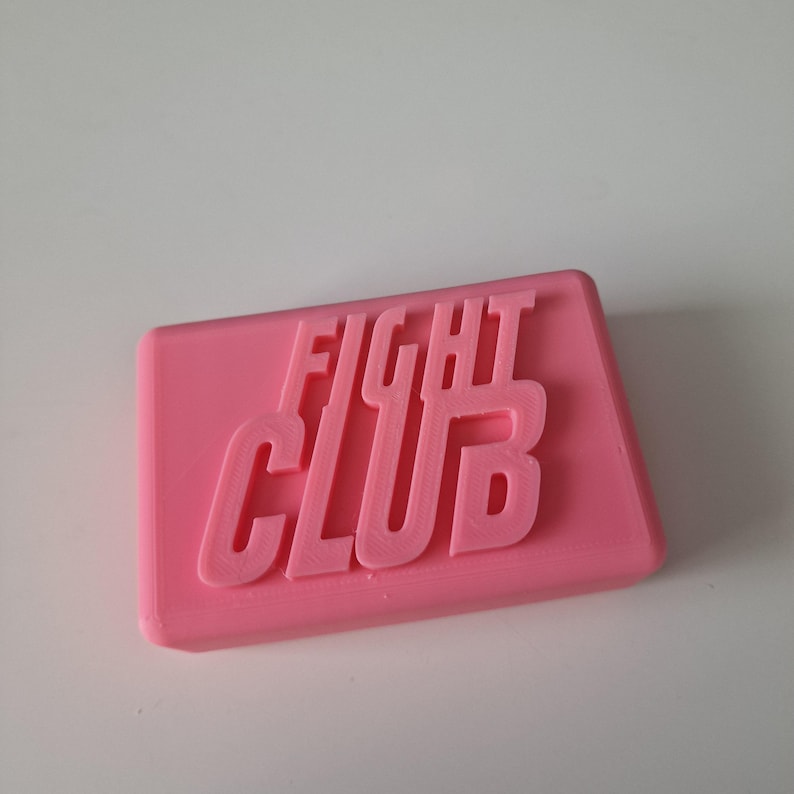 May include: A pink rectangular soap bar with the words "FIGHT CLUB" embossed on the top.