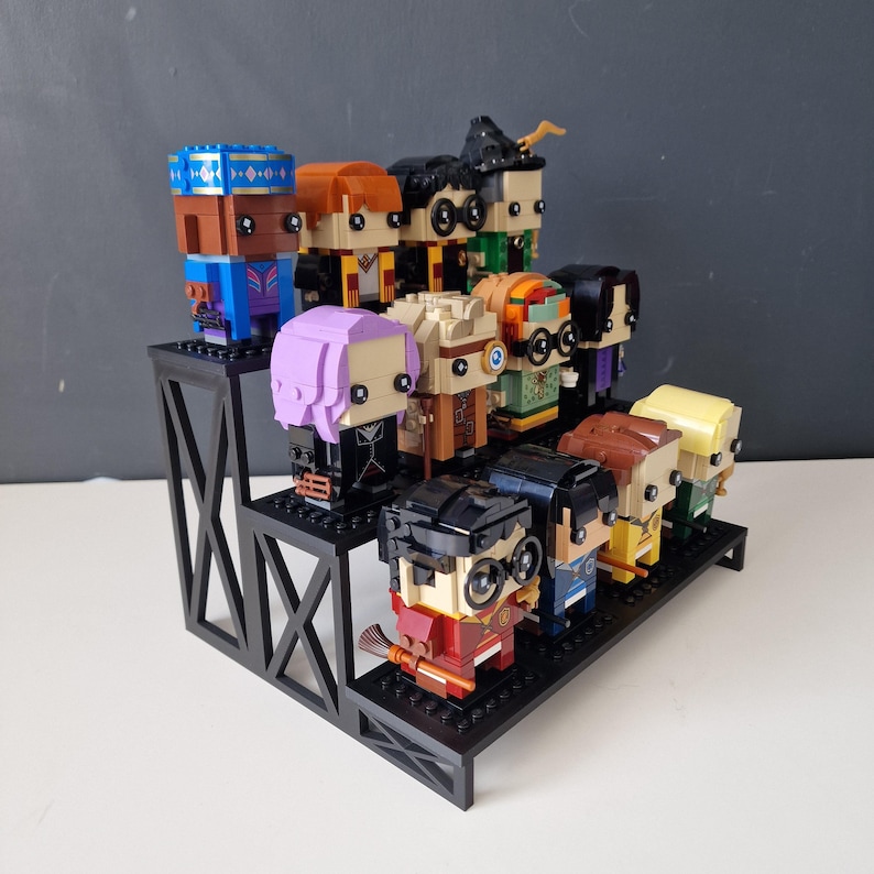 Puede incluir: Un expositor negro de dos niveles con 12 minifiguras Lego de colores de personajes de la serie Harry Potter. Las minifiguras est&aacute;n dispuestas en dos filas en el expositor.