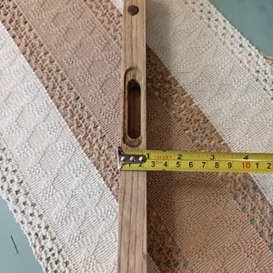 Pu&ograve; includere: Un livello in legno con un piccolo foro al centro. Il livello &egrave; lungo 25,4 cm e ha un metro a nastro giallo attaccato.
