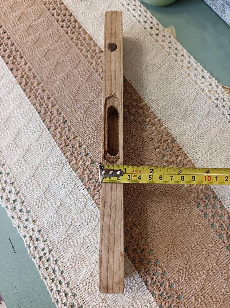 Pu&ograve; includere: Un livello in legno con un piccolo foro al centro. Il livello &egrave; lungo 25,4 cm e ha un metro a nastro giallo attaccato.