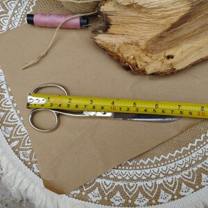 May include: A yellow measuring tape and silver scissors on a brown paper background. The tape measure reads 12 inches and 20 centimeters.