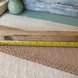 Pu&ograve; includere: Un livello in legno con un livello a bolla in metallo al centro. Il livello &egrave; lungo circa 50 cm.