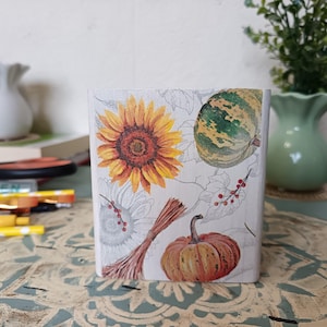 Puede incluir: Una caja de madera blanca con un dise&ntilde;o de tem&aacute;tica oto&ntilde;al. La caja presenta un girasol, una calabaza y una calabaza. El dise&ntilde;o est&aacute; impreso en la caja y tiene un aspecto vintage.