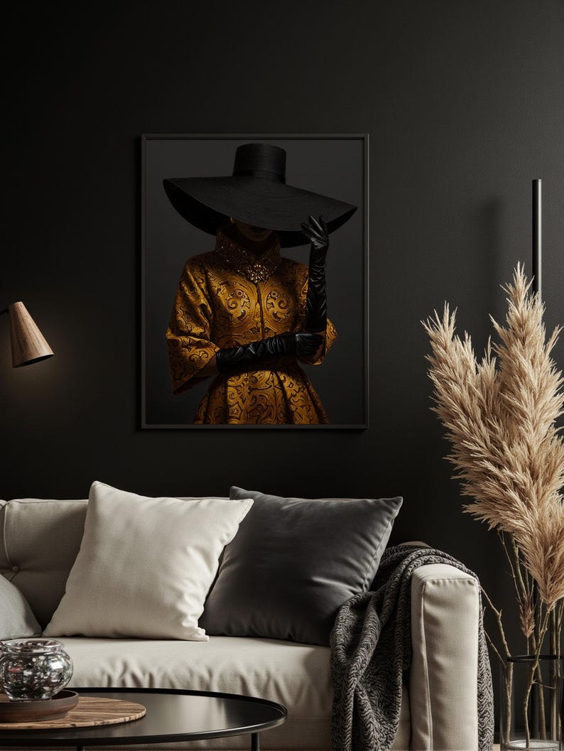 Op de afbeelding: Een zwart en gouden ingelijste print van een vrouw die een brede zwarte hoed en een gouden geprinte jurk draagt.