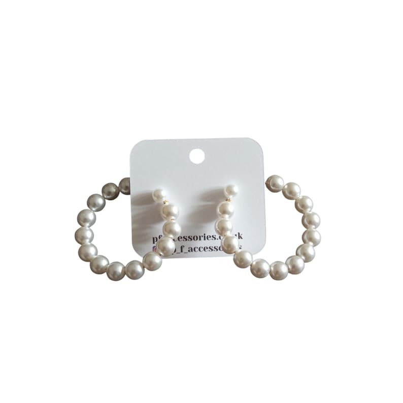 May include: A pair of white pearl hoop earrings. The earrings are made of small, round pearls that are strung together to form a hoop shape. The hoops are about 2 inches in diameter.