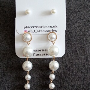 May include: A set of pearl earrings with a single pearl stud and a pair of drop earrings with three pearls each. The earrings are on a white card with the text "pfaccessories.co.uk @p_f_accessories".