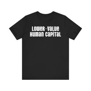 以下が含まれることがあります： 白い文字で「LOWER-VALUE HUMAN CAPITAL」と書かれた黒いTシャツ。テキストは太字のサンセリフ体です。Tシャツはクルーネックで、テキストは胸の中央に配置されています。