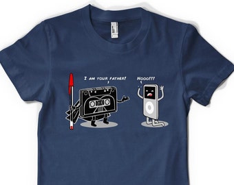 Può includere: Una t-shirt blu navy con una grafica di un nastro cassette vestito da Darth Vader e un iPod con il testo "Io sono tuo padre!" e "Nooo!!!".