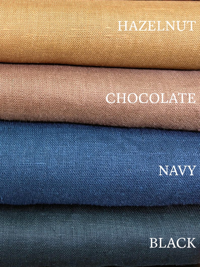 May include: Four stacked layers of woven fabric in distinct colors. The top layer is labeled HAZELNUT, followed by a layer labeled CHOCOLATE, a layer labeled NAVY, and a bottom layer labeled BLACK. Each fabric shows a visible, textured weave pattern.
