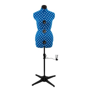 May include: A blue and white polka dot dress form on a black adjustable stand. The dress form has a bust, waist, and hips.