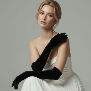 May include: Elegant black velvet opera gloves. The gloves are long, extending past the elbows, and are made of a soft, luxurious fabric. The gloves are a classic accessory, often worn for formal events.
