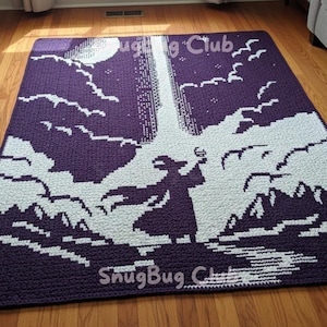 以下が含まれることがあります： 月、雲、光のビームを背景に、魔法使いのシルエットが描かれたかぎ針編みのブランケット。ブランケットは主に紫と白で、「SnugBug Club」の文字が下部にあります。