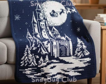 May include: A navy blue and white crocheted blanket featuring a castle design under a full moon with Santa's sleigh. The blanket is draped over a gray sofa. The text "SnugBug Club" is visible.
