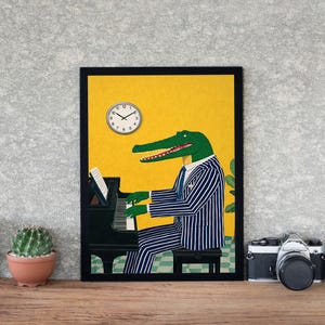 May include: A framed art print featuring an alligator playing a grand piano. The alligator is wearing a blue and white striped suit and tie. A clock is visible in the upper left corner. The background is yellow.