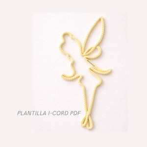 Puede incluir: Un diseño amarillo en forma de hada hecho de un cordón, sobre un fondo blanco. El texto "PLANTILLA I-CORD PDF" está impreso en negro en la parte inferior. El hada tiene alas extendidas y una silueta fluida.