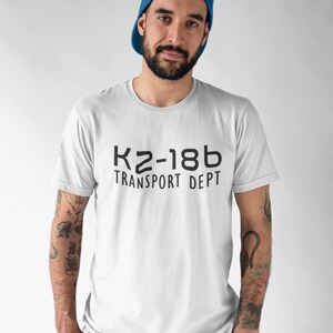 May include: White t-shirt with black text that reads "KZ-18b Transport Dept."