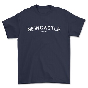 May include: A navy blue t-shirt with white text that reads "NEWCASTLE ENGLAND".