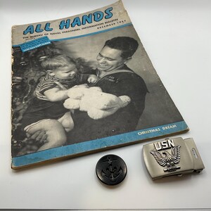 Peut inclure: Magazine vintage "All Hands" de décembre 1945, avec un marin et un enfant en couverture. Comprend un bouton d'ancre noir et une boucle de ceinture USN argentée avec un emblème d'aigle. La couverture du magazine indique "Christmas Dream".