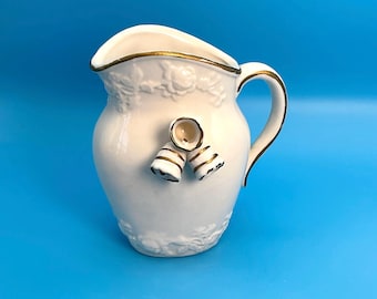 Jarra de crema de porcelana antigua pintada a mano, con diseño floral blanco y dorado y detalle de campana