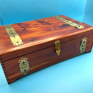 Scatola del tesoro in legno con piedini vintage: cinghie, chiavistello e cerniere decorati in ottone