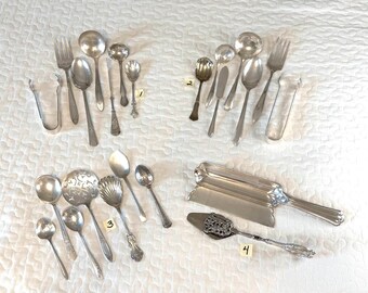 Könnte beinhalten: Eine Sammlung von silberfarbenem Besteck und Servierutensilien, angeordnet in vier Gruppen, die mit 1 bis 4 beschriftet sind. Das Set enthält verschiedene Löffel, Gabeln, Zangen, ein Buttermesser, einen dekorativen Heber und ein rechteckiges Tablett.