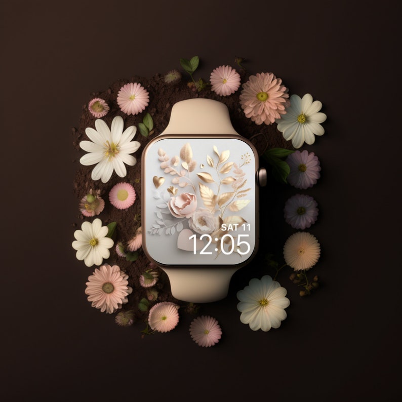 May include: A gold smartwatch with a white band and a floral watch face. The watch face displays the time as 12:05 and the date as SAT 11. The watch is surrounded by small pink and white flowers.